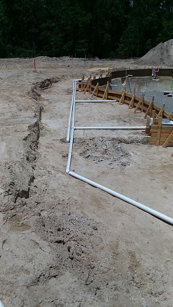 Early plumbing rough-in and pool shell formwork during construction at Hawthorne at Smith Creek.